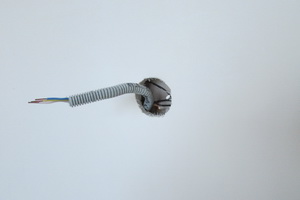 Вывод электрического кабеля в гофре в месте из под розетки